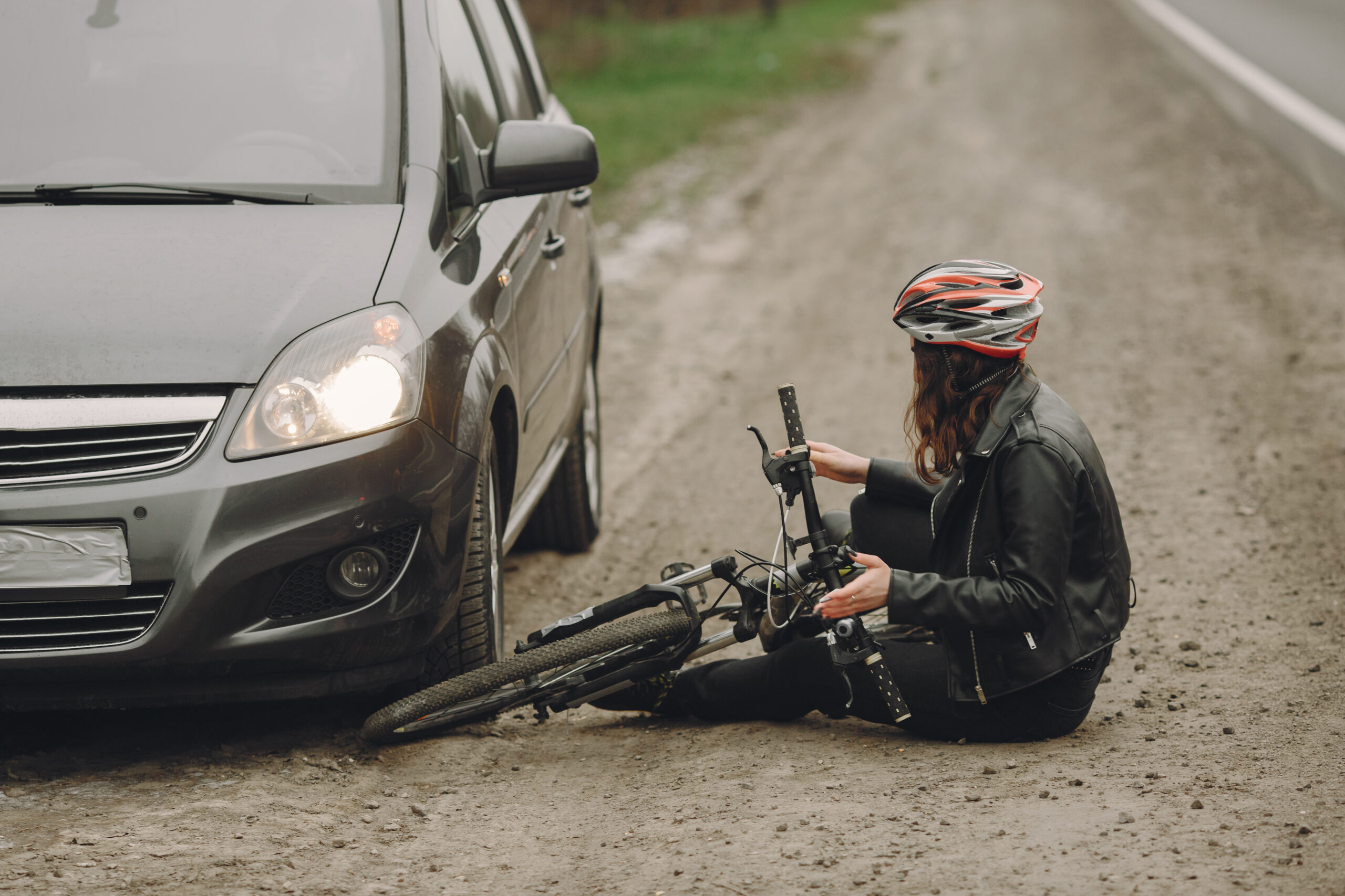 Road accident with cyclist woman driver and car